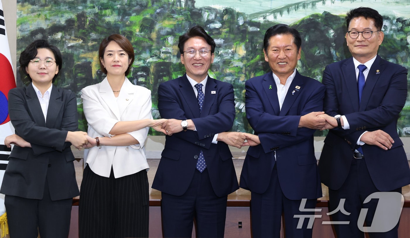 더불어민주당 당권에 도전하는 김보미(왼쪽부터)·고민정·김민석·정청래·송영길 후보가 21일 서울 중구 서울시의회에서 열린 당대표 후보자 초청 간담회에 앞서 손을 맞잡은 채 기념촬영을 하고 있다. 2026.7.21 ⓒ 뉴스1 오대일 기자