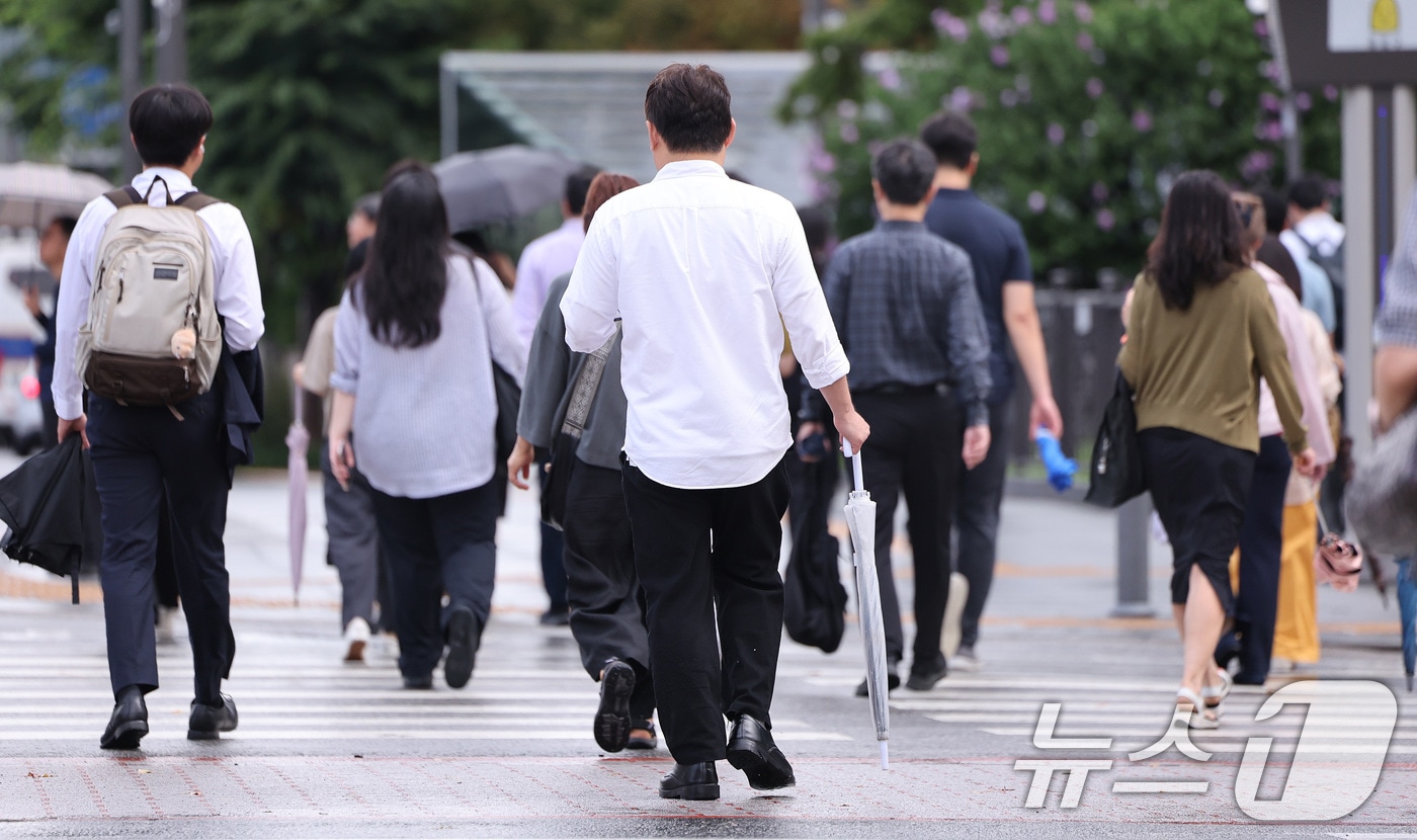 7일 서울 광화문네거리에서 출근하는 시민들이 비가 내렸다 그치기를 반복하는 날씨 속에 우산을 손에 든 채 발걸음을 옮기고 있다. 2026.7.7 ⓒ 뉴스1 박지혜 기자