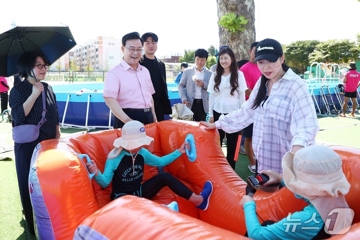 김성제 경기 의왕시장(왼쪽 두 번째)이 8일 부곡초등학교에 마련된 '부곡동 아동 물놀이장'을 찾아 시설 운영과 안전관리 상황을 점검하고 있다. (의왕시 제공. 재판매 및 DB 금지) 2026.8.10/뉴스1