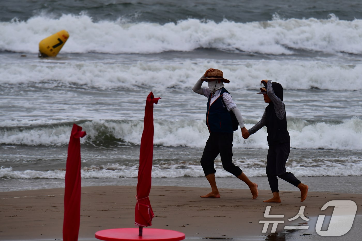 12일 오전 경북 포항시 북구 영일대해수욕장 백사장에서 아침 운동을 나온 시민들이 15호 태풍 '찬홈'의 영향으로 발생한 강풍과 높은 파도를 피해 걸어가고 있다. 2026.8.12 ⓒ 뉴스1 최창호 기자