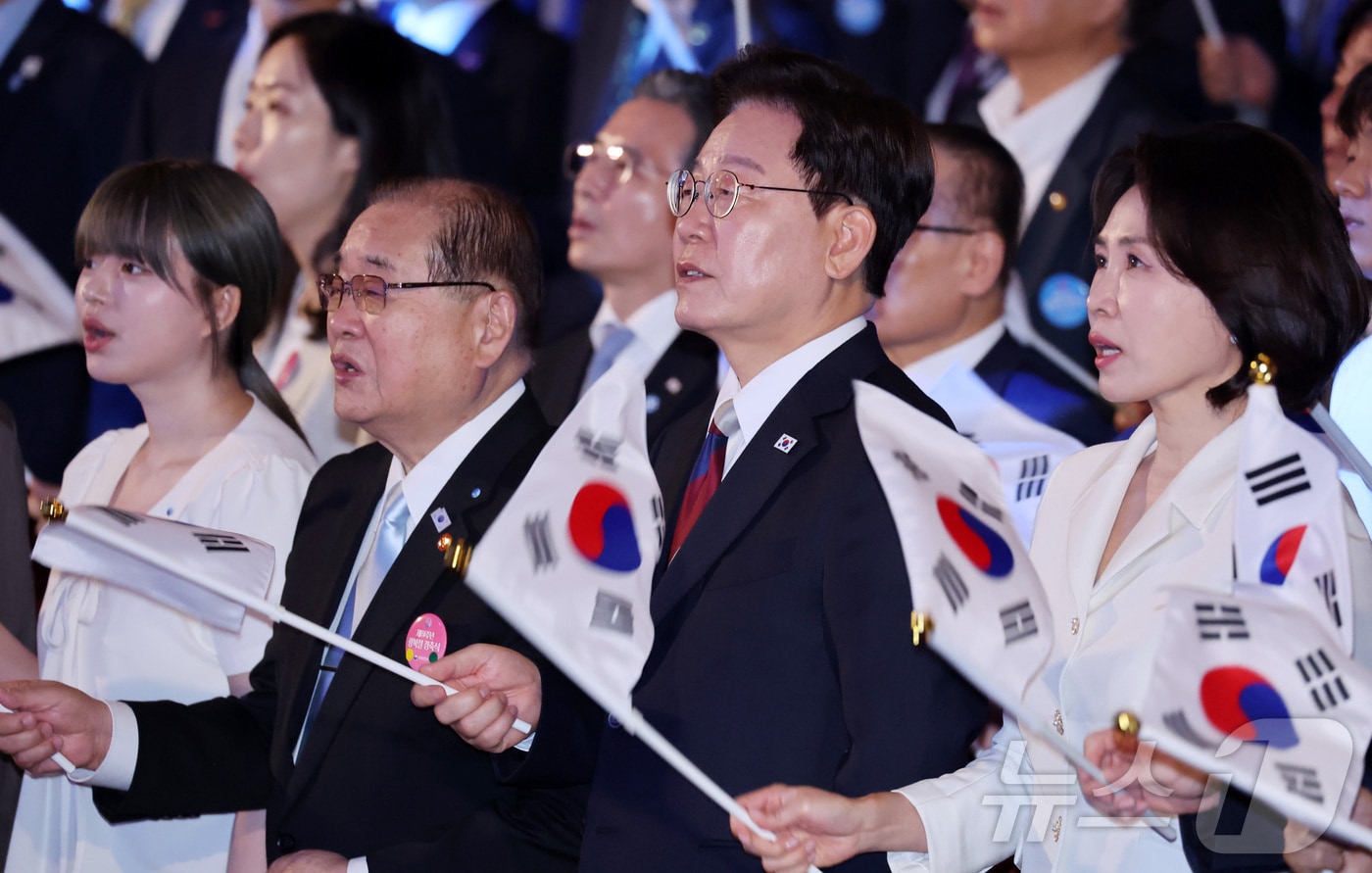 이재명 대통령과 김혜경 여사가 15일 서울 종로구 세종문화회관에서 열린 제81주년 광복절 경축식에서 광복절 노래를 제창하며 태극기를 흔들고 있다. 2026.8.15 ⓒ 뉴스1 이재명 기자