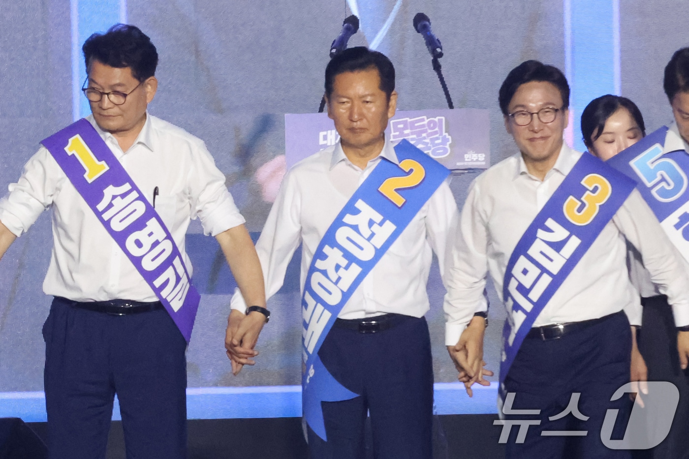 더불어민주당 송영길(왼쪽부터), 정청래, 김민석 당대표 후보가 17일 오후 대전 유성구 DCC대전컨벤션센터에서 열린 '제3차 정기전국당원대회'에서 인사를 위해 손을 잡고 있다. 2026.8.17 ⓒ 뉴스1 황기선 기자
