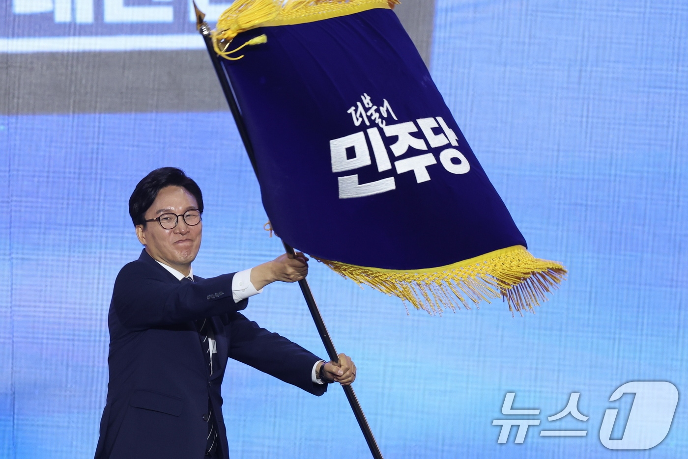 김민석 신임 더불어민주당 대표가 17일 오후 대전 유성구 DCC대전컨벤션센터에서 열린 '더불어민주당 제3차 정기전국당원대회'에서 당기를 흔들고 있다. 2026.8.17 ⓒ 뉴스1 황기선 기자