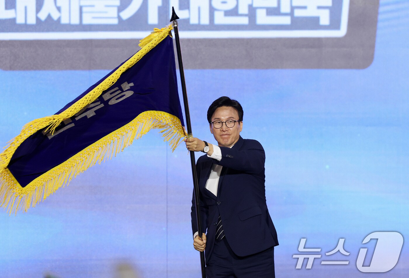 김민석 신임 더불어민주당 대표가 17일 오후 대전 유성구 DCC대전컨벤션센터에서 열린 '더불어민주당 제3차 정기전국당원대회'에서 당기를 흔들고 있다. 2026.8.17 ⓒ 뉴스1 황기선 기자