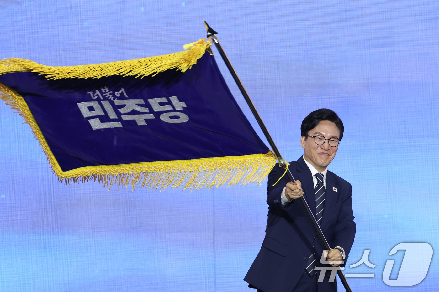 김민석 신임 더불어민주당 대표가 17일 오후 대전 유성구 DCC대전컨벤션센터에서 열린 '더불어민주당 제3차 정기전국당원대회'에서 당기를 흔들고 있다. 2026.8.17 ⓒ 뉴스1 황기선 기자