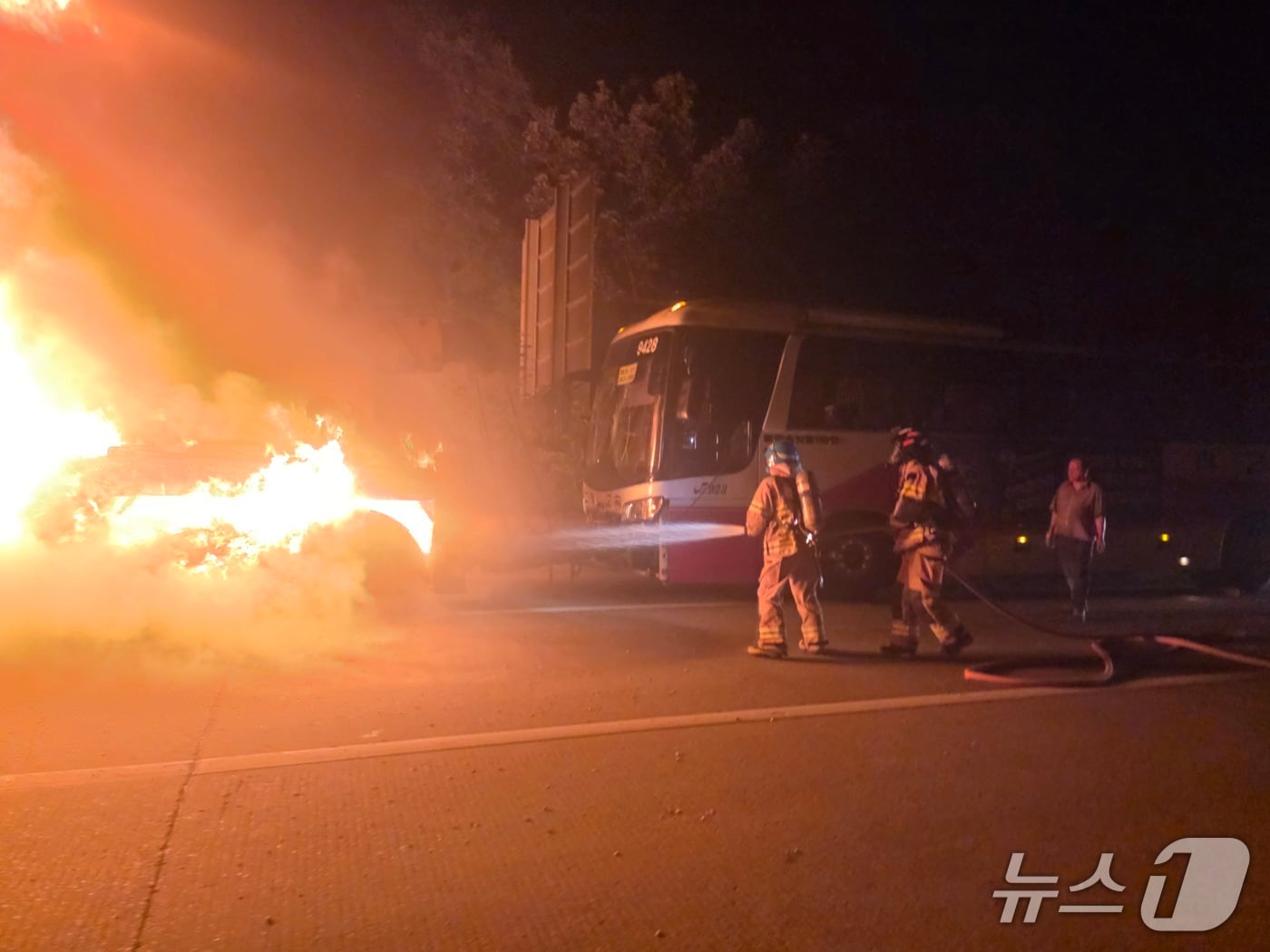 18일 오전 2시 30분쯤 경북 구미시 옥성면 중부내륙고속도로 창원 방향 선산휴게소 인근에서 사고로 파손된 대형 버스를 견인해 가던 견인차에서 불이 나 진화 대원들이 불을 끄고 있다.(송영훈씨 제공. 재판매 및 DB 금지)2026.8.18/뉴스1
