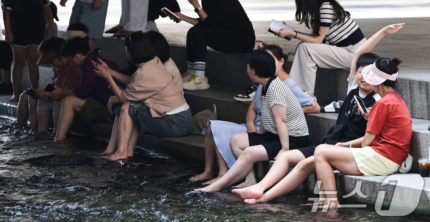 서울 일부 지역에 폭염주의보가 다시 발효된 18일 서울 청계천에서 시민들이 휴식을 취하고 있다. 이날 서울의 낮 최고기온은 32도까지 오르고 높은 습도로 최고체감온도는 33도 안팎을 보일 것으로 예보됐다. 2026.8.18 ⓒ 뉴스1 이종수 기자