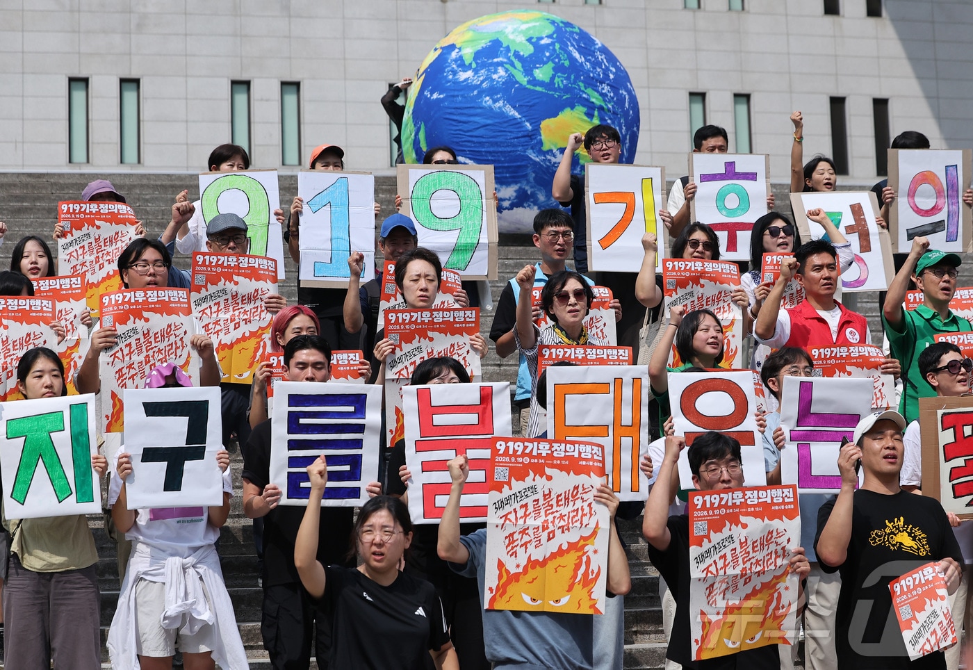 9·19기후정의행진 조직위원회 관계자들이 19일 서울 종로구 세종문화회관 계단에서 열린 '지구를 불태우는 폭주를 멈춰라' 선포식에서 퍼포먼스를 하고 있다. 2026.8.19 ⓒ 뉴스1 김성진 기자