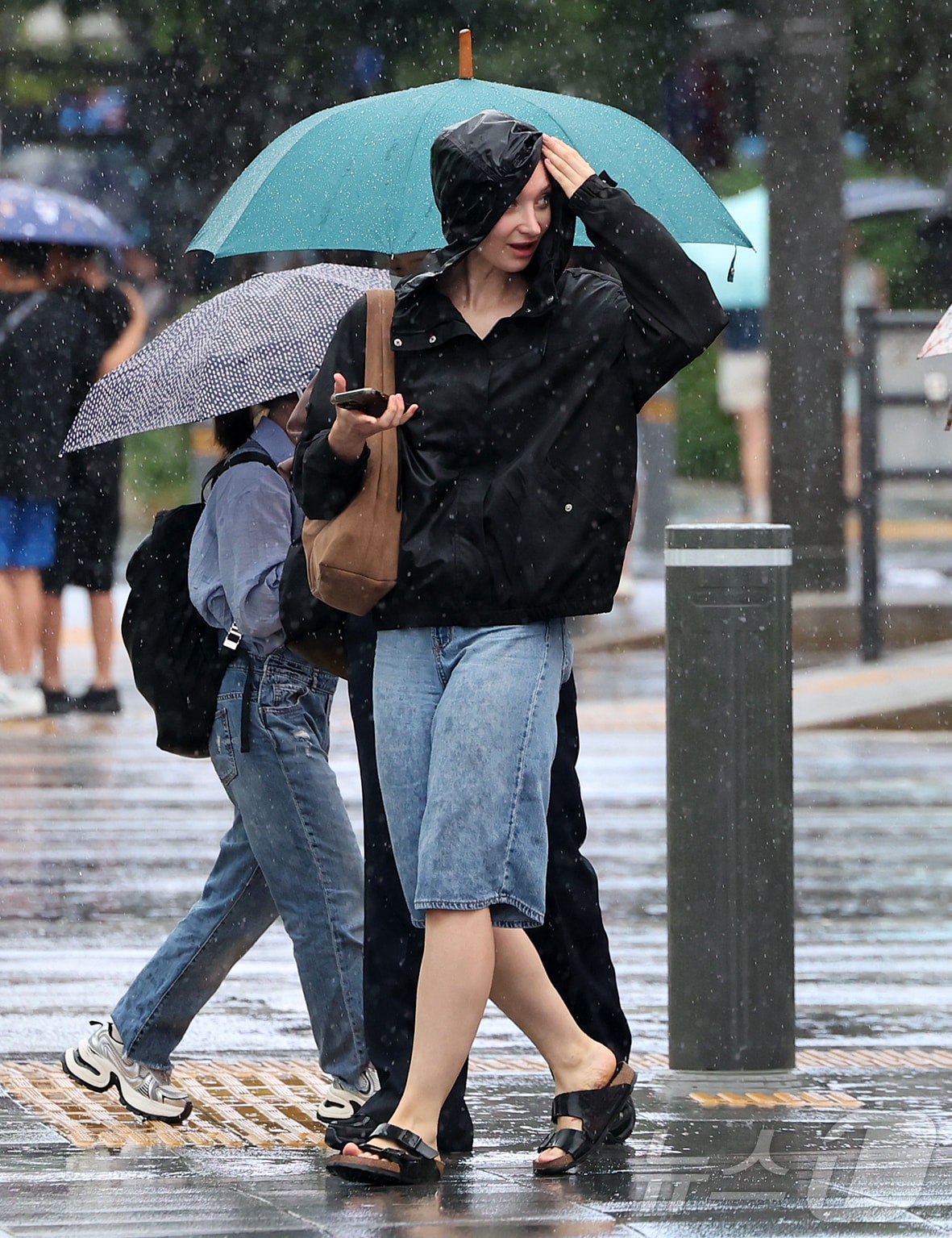비가 내린 22일 오후 서울 종로구 광화문 사거리에서 외국인 관광객이 비를 피하며 횡단보도를 건너고 있다. 2026.8.22 ⓒ 뉴스1 김진환 기자