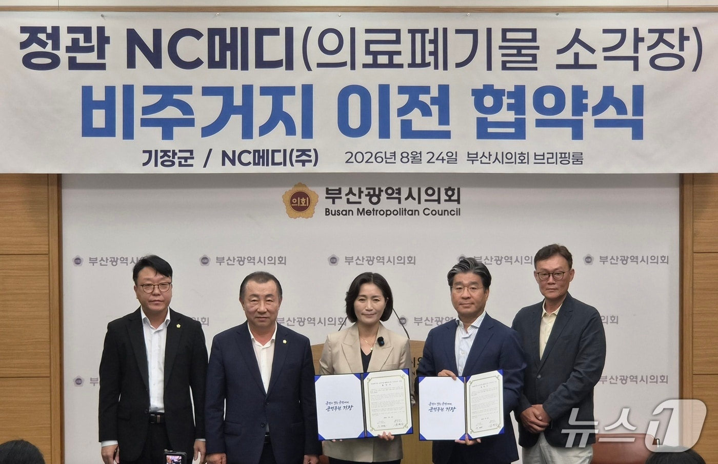 우성빈 부산 기장군수와 강경진 NC메디 회장이 정관 의료폐기물 소각장 비주거지 이전 협약 체결을 하고 있다.(사진 왼쪽부터 라기오 부산시의회 의원, 김원일 기장군의회 의장, 우성빈 기장군수, 강경진 NC메디 회장, 김성훈 NC메디 본부장) 2026.8./24뉴스1 ⓒ News1 임순택 기자