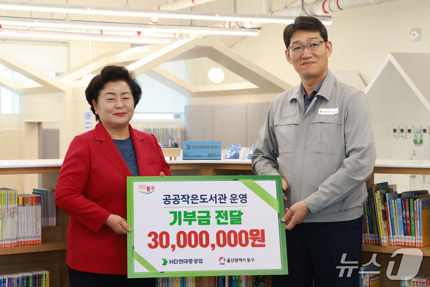 HD현대중공업 이준엽 상생·총무부문장(오른쪽)과 천기옥 울산 동구청장(왼쪽)이 25일 책놀이터 북적북적에서 기부금 전달식을 가지고 기념사진을 찍고 있다.(울산 동구 제공. 재판매 및 DB금지)/뉴스1