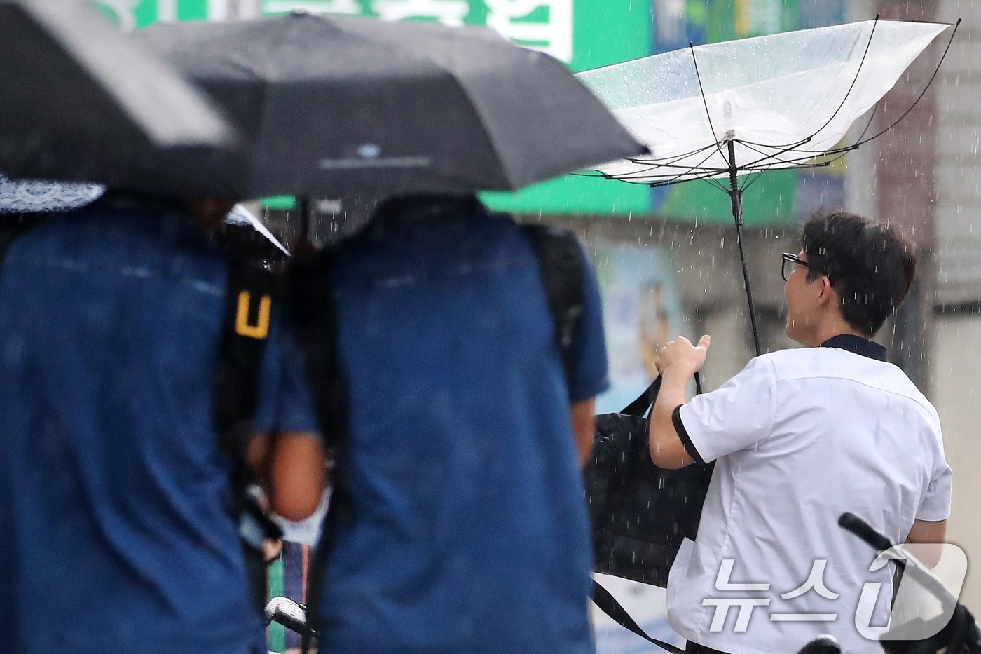 27일 오후 대구 수성구 달구벌대로 담티고개 인근에 천둥번개를 동반한 비가 내리자 하굣길 한 학생이 뒤집힌 우산을 펴고 있다. 2026.8.27 ⓒ 뉴스1 공정식 기자