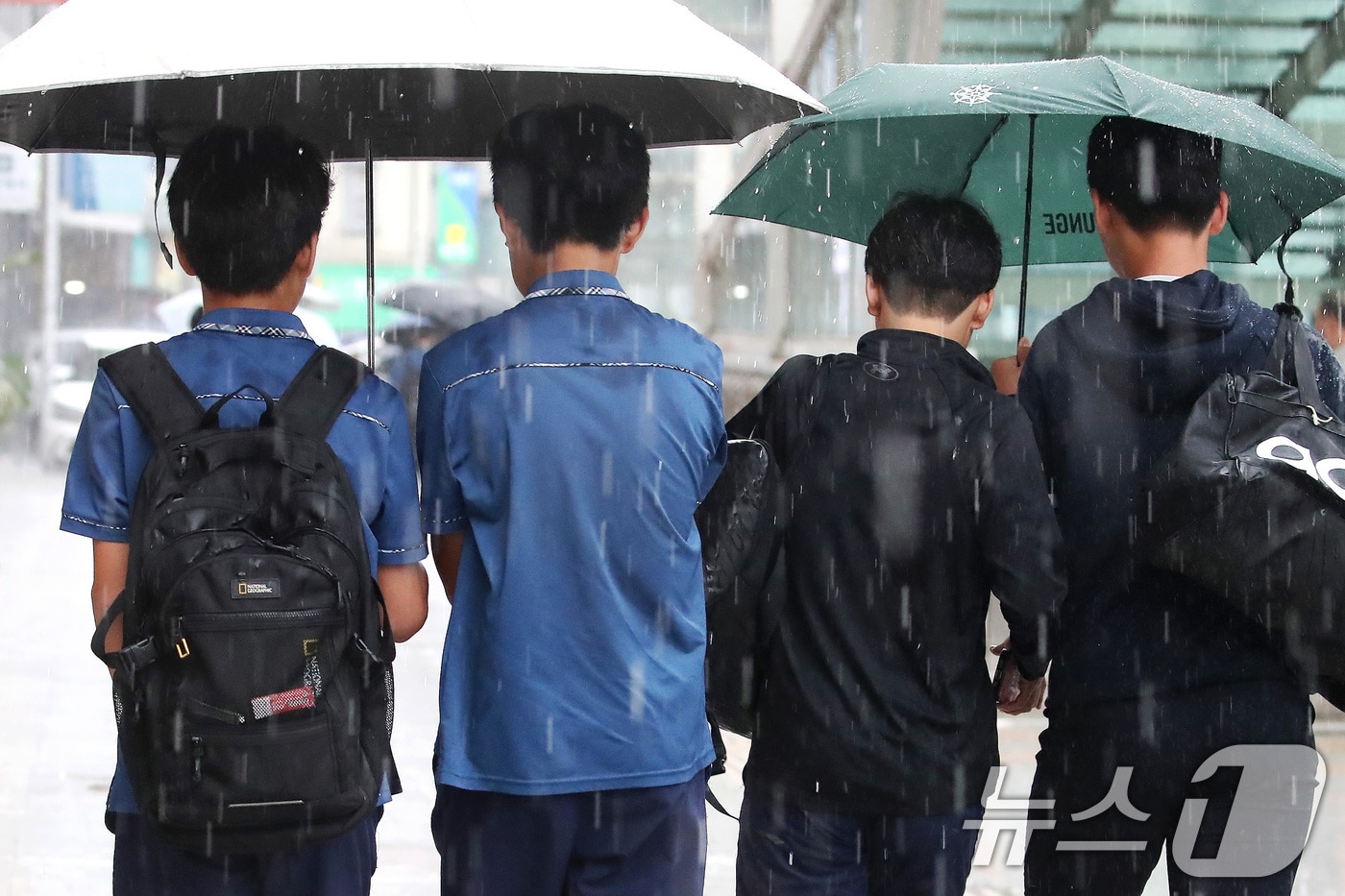 27일 오후 대구 수성구 달구벌대로 담티고개 인근에 천둥번개를 동반한 소나기가 내리자 하굣길 학생들이 우산으로 비를 피하며 발걸음을 재촉하고 있다. 2026.8.27 ⓒ 뉴스1 공정식 기자