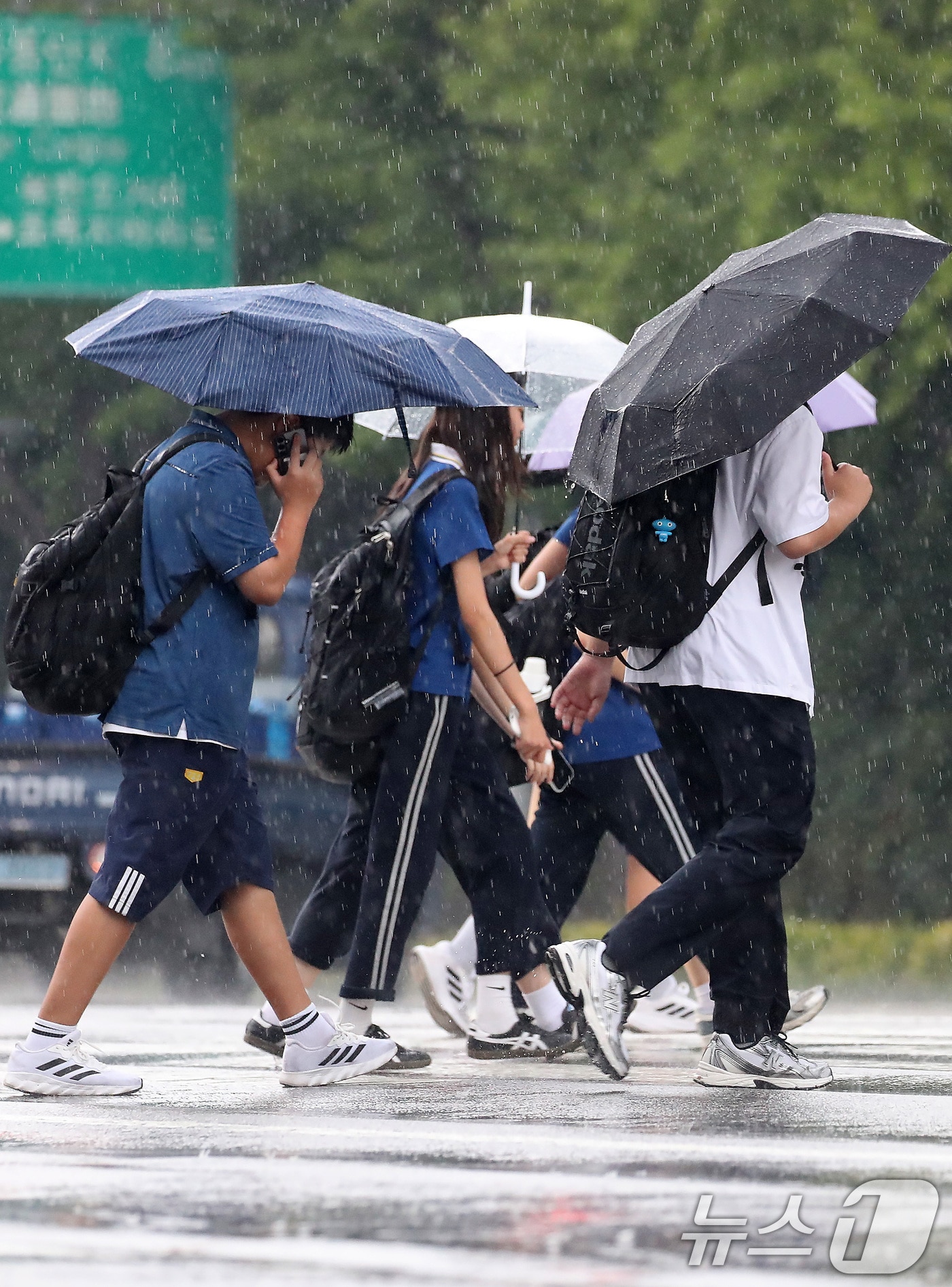 27일 오후 대구 수성구 달구벌대로 담티고개 인근에 천둥번개를 동반한 비가 내리자 하굣길 학생들이 발걸음을 재촉하고 있다. 2026.8.27 ⓒ 뉴스1 공정식 기자
