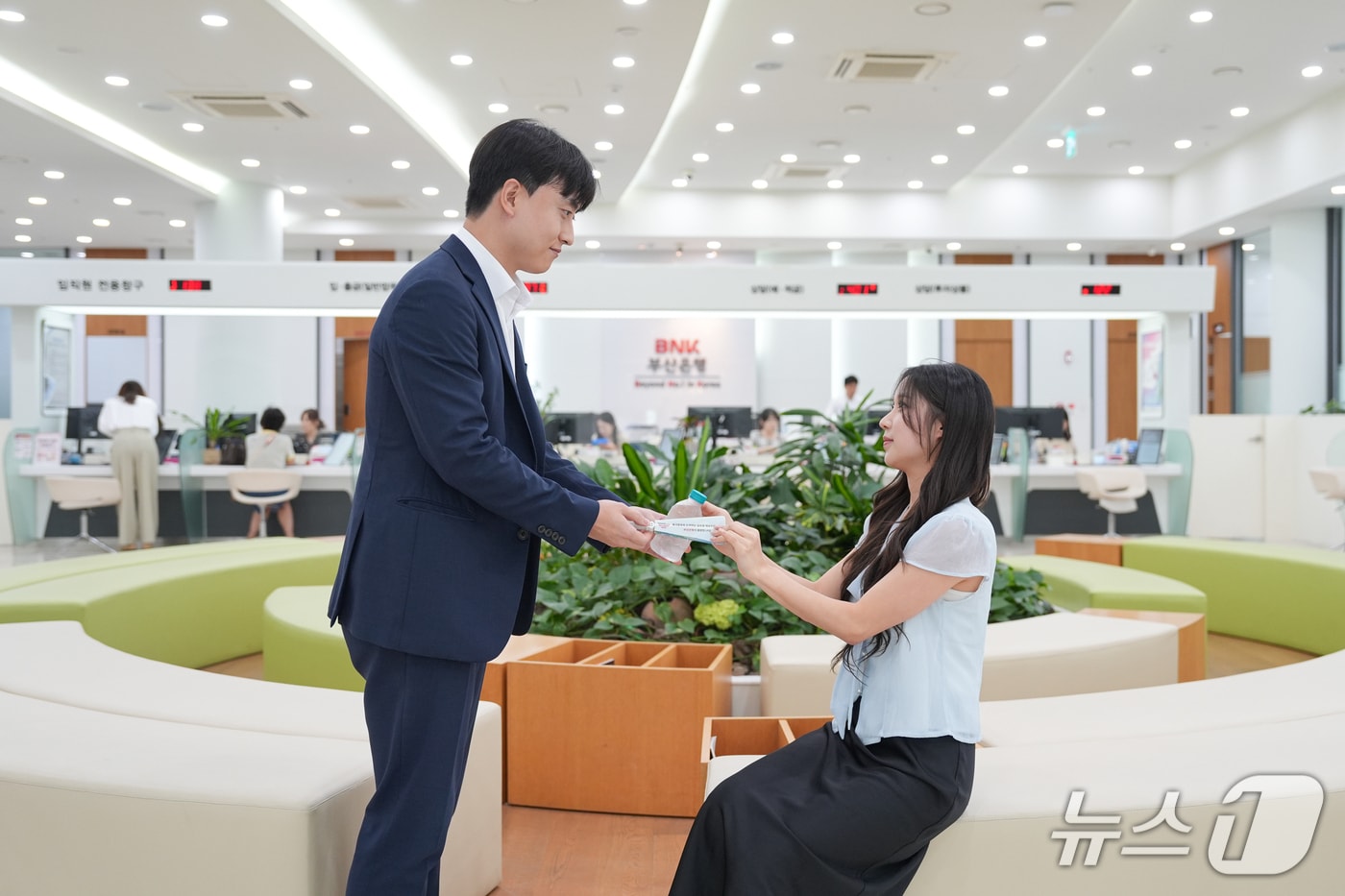 우리동네 기후쉼터로 운영되는 한 부산은행 영업점을 찾은 고객에 생수 등을 전달하는 모습 (BNK금융 제공. 재판매 및 DB금지)