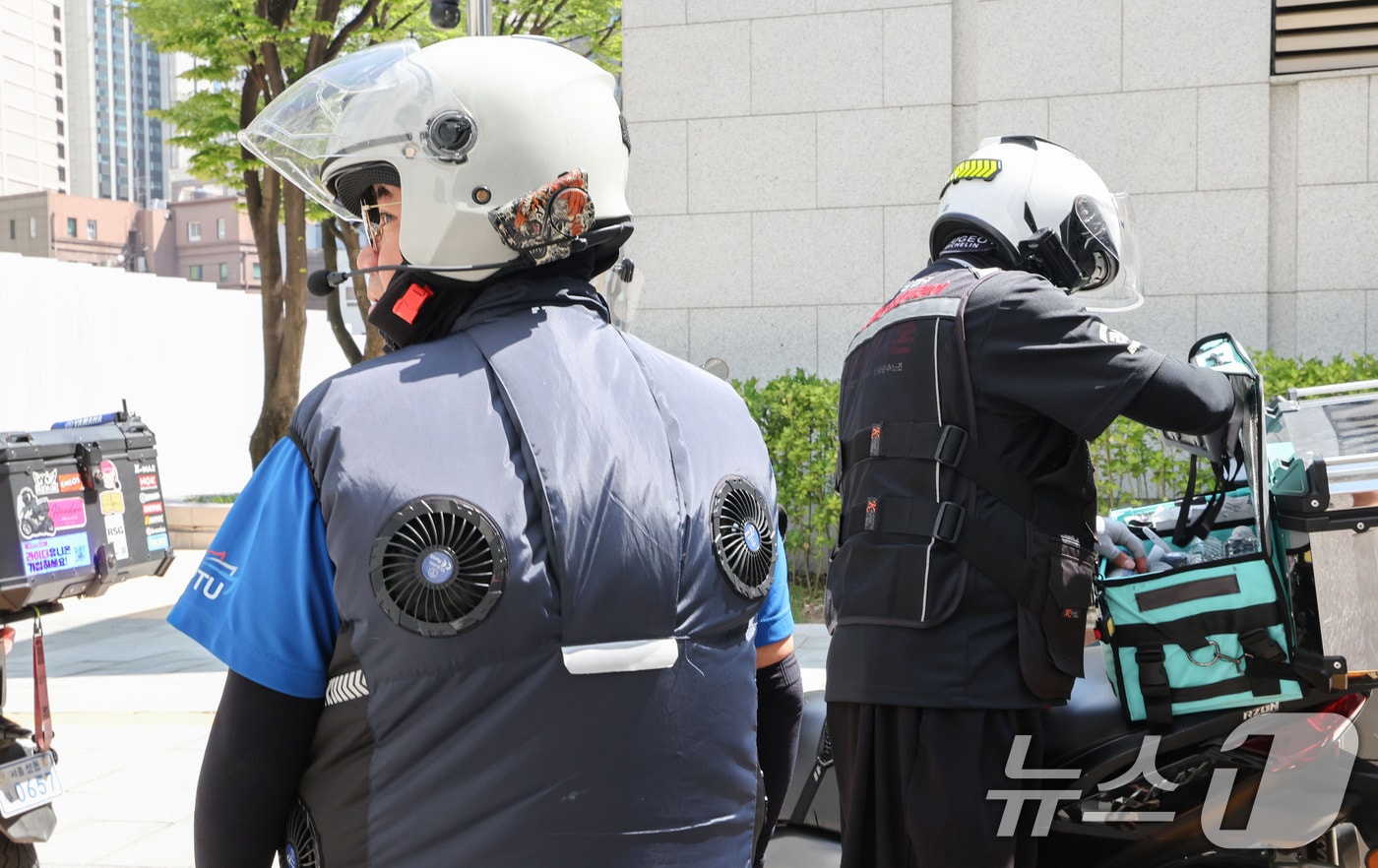 배달라이더가 선풍기가 달린 냉각 자켓을 입고 휴식을 취하고 있는 모습. ⓒ 뉴스1 이종수 기자