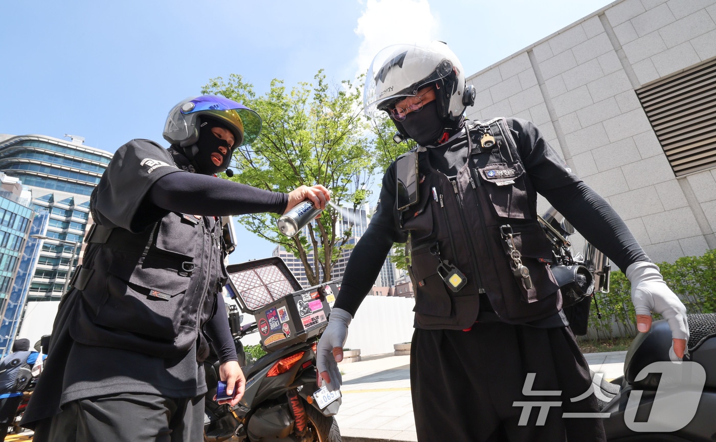 연일 폭염이 이어지는 7일 서울 중구 북창쉼터 앞에서 배달라이더가 쿨링 스프레이를 뿌리고 있다. 2026.8.7 ⓒ 뉴스1 이종수 기자