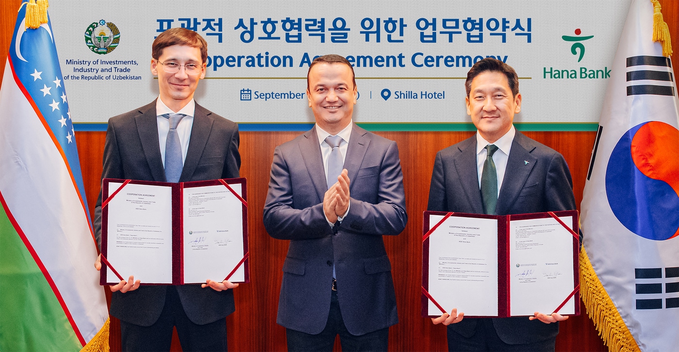 하나은행은 지난 11일 오후 우즈베키스탄 투자산업통상부와 투자·금융 협력을 위한 업무협약을 체결했다. 협약식에 참석한 윤태선 하나은행 글로벌사업본부 본부장(사진 오른쪽)이 라지즈 쿠드라토프 우즈베키스탄 투자산업통상부 장관(사진 가운데), 굴라모프 우즈베키스탄 투자산업통상부 차관(사진 왼쪽)과 함께 협약서를 들고 기념촬영을 하고 있다.(하나은행 제공)
