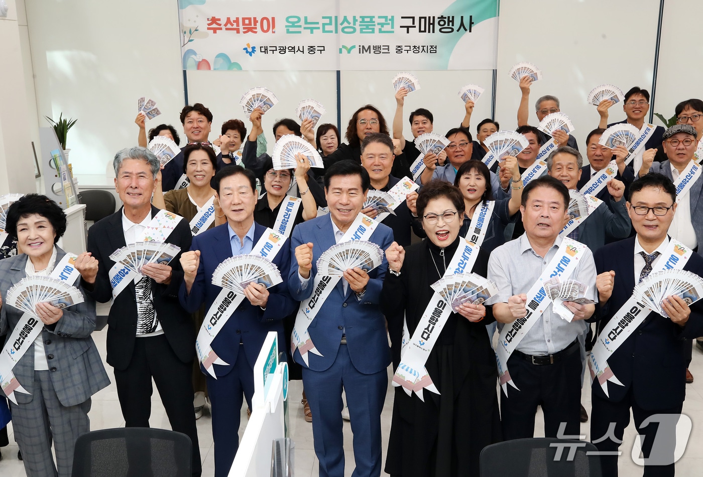 14일 대구 중구 iM뱅크 중구청지점에서 열린 '2026년 추석맞이 온누리상품권 구매 행사'에서 류규하 중구청장, 유성자 중구의회 의장, 임인환 대구시의회 의장, 서문시장상인회, 중구 주민, 중구청 직원 등 참석자들이 전통시장 활성화를 위해 구매한 온누리상품권을 펼쳐 보이고 있다. 2026.9.14 ⓒ 뉴스1 공정식 기자