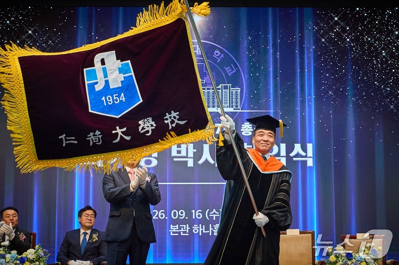 최기영 인하대 총장이 성용락 정석인하학원 이사장으로부터 받은 교기를 흔들고 있다. (인하대 제공.재판매 및 DB금지)