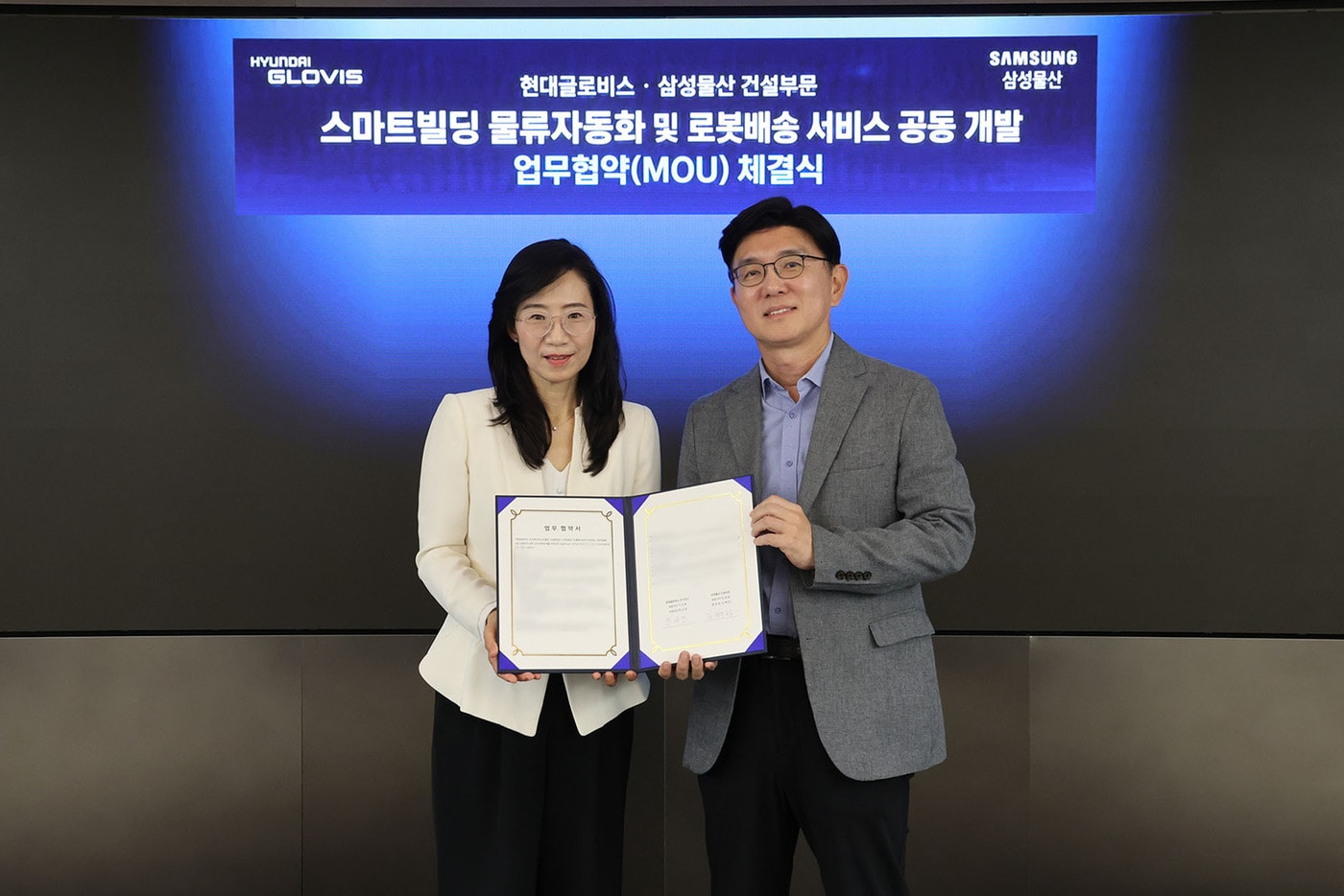  한규헌 현대글로비스 미래혁신기술센터장(오른쪽)과 조혜정 삼성물산 DxP본부장이 '스마트빌딩 물류자동화 및 로봇배송 서비스 공동 개발 관련 업무협약(MOU)' 체결 후 기념사진을 찍고 있다. (현대글로비스 제공)