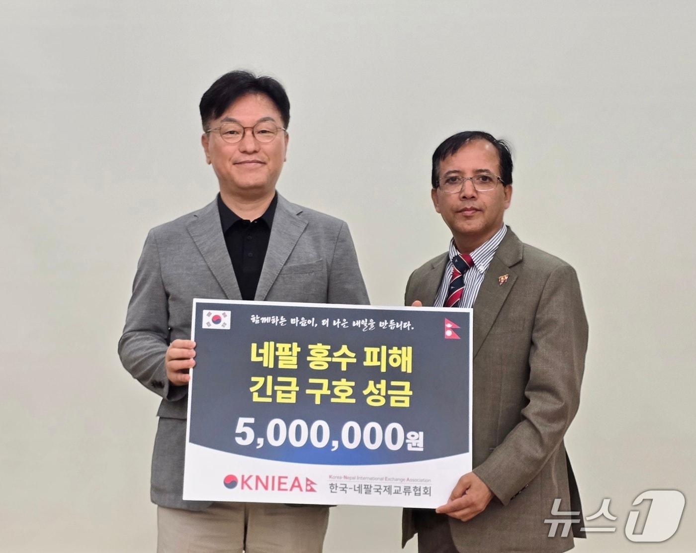 김용수 한국-네팔국제교류협회 상임대표(왼쪽)가 21일 부산 국립부경대학교에서 니르말 프라사드 바타라이 주한 네팔 대리대사를 만나 네팔 대규모 홍수 피해 복구 및 이재민 지원을 위한 구호 성금을 전달하고 있다. (한국-네팔국제교류협회 제공. 재판매 및 DB금지)