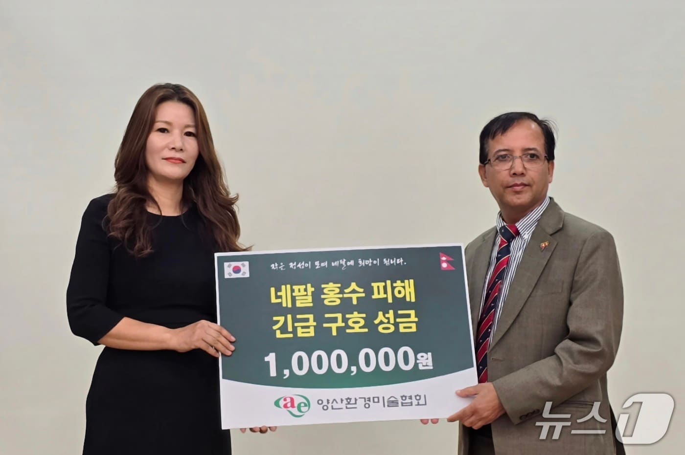 이명희 양산환경미술협회장(왼쪽)이 지난 20일 부산 국립부경대학교에서 니르말 프라사드 바타라이 주한 네팔 대사대리를 만나 네팔 대규모 홍수 피해 복구와 이재민 지원을 위한 구호 성금을 전달하고 있다. (양산환경미술협회 제공. 재판매 및 DB금지) , 주한 네팔대사관에 홍수 구호 성금 전달