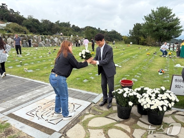 성묘객이 생화로 추모하는 모습.(전남광주통합특별시 제공. 재판매 및 DB 금지.)