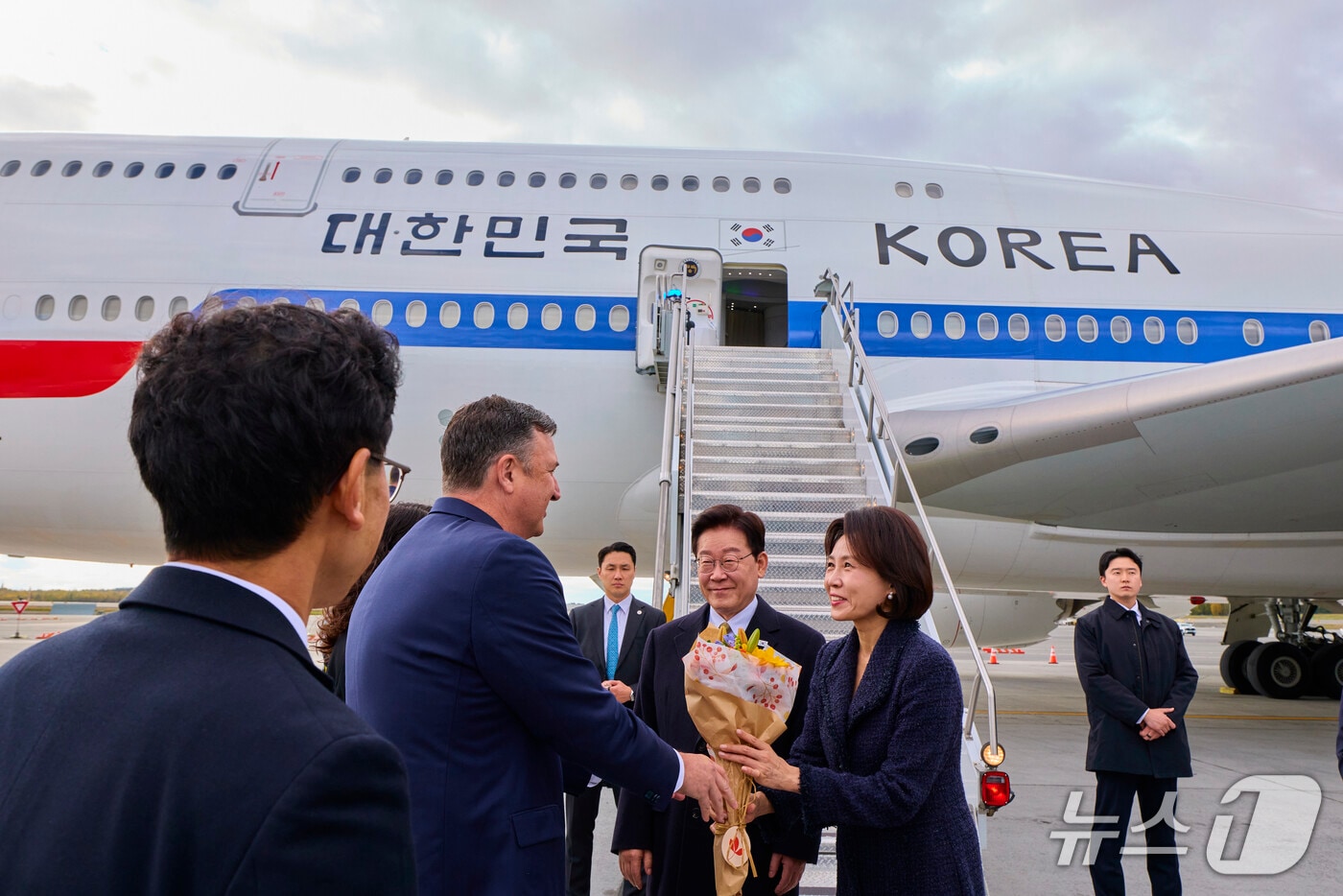 이재명 대통령과 김혜경 여사가 26일(현지시간) 순방 귀국길 경유지인 미국 앵커리지에 도착해 환영객에게 꽃다발을 전달 받고 있다. (공동취재) 2026.9.27 ⓒ 뉴스1 허경 기자