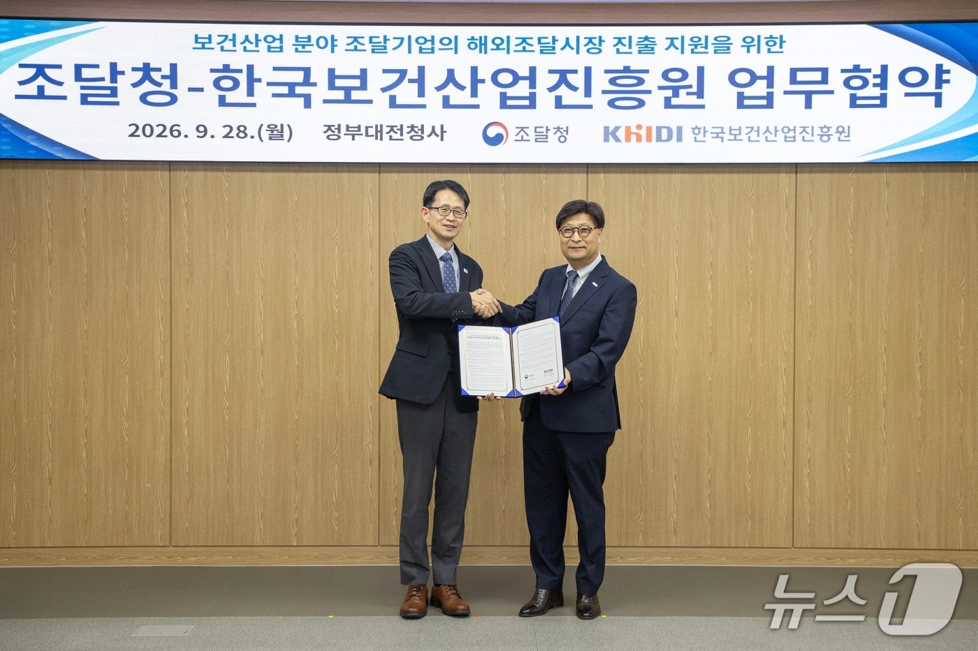 백승보 조달청장(왼쪽)과 고상백 한국보건산업진흥원장이 28일 정부대전청사에서 '보건산업 분야 기업의 해외조달시장 진출 지원을 위한 업무협약'을 맺고 악수를 하고 있다. (조달청 제공. 재판매 및 DB금지) /뉴스1