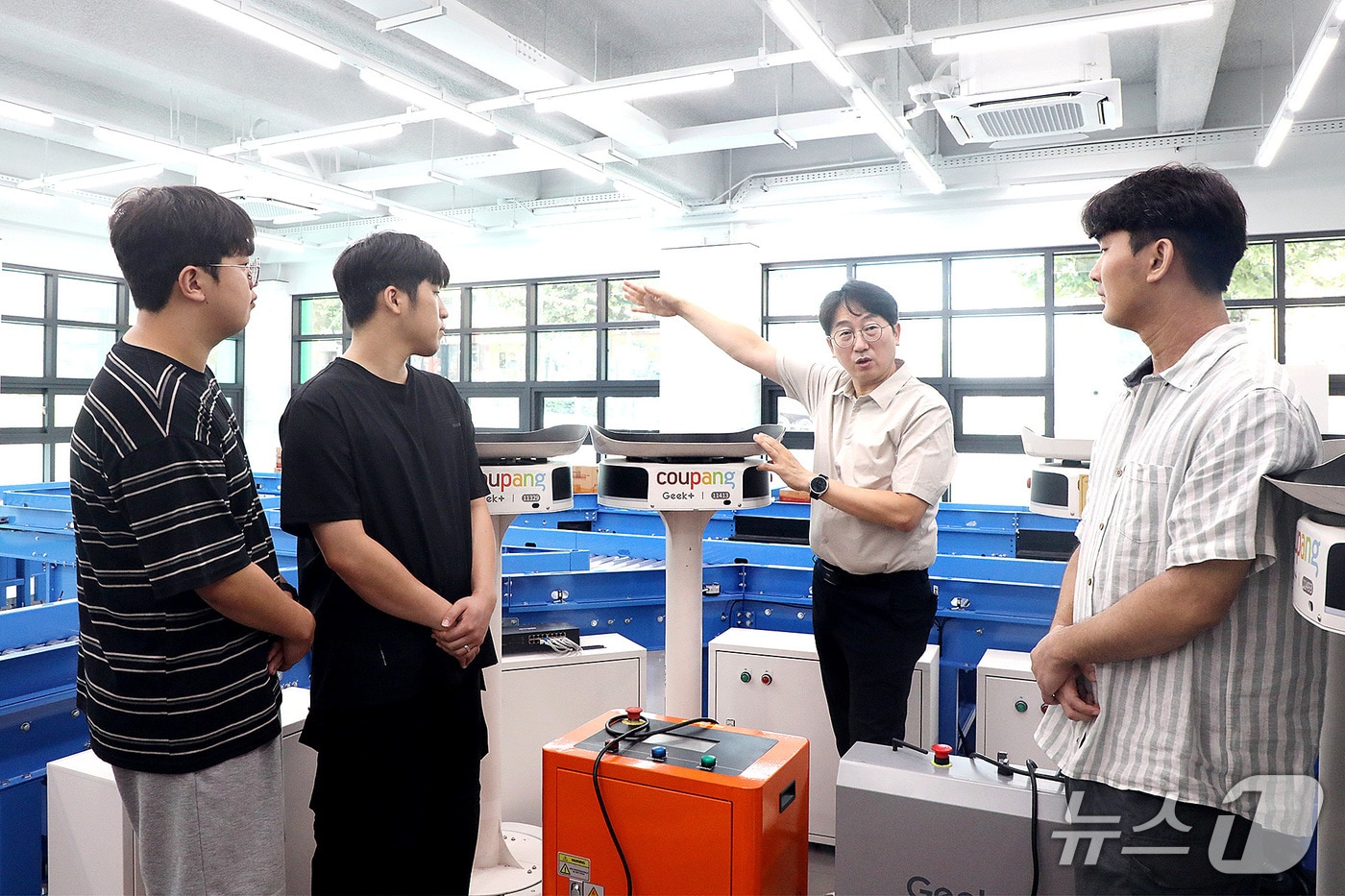 성금길 교수(오른쪽 두번째)가 AI물류교육센터에서 AI 기반 물류자동화 시스템을 설명하고 있다. (영남이공대 제공. 재판매 및 DB 금지)