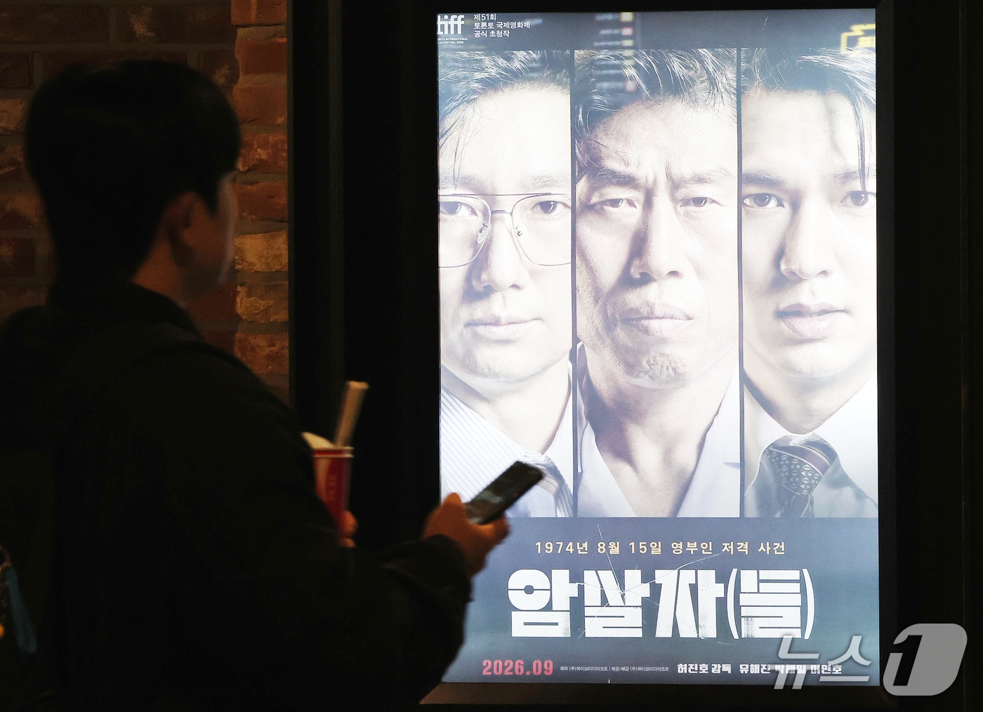 영화 ‘암살자(들)’이 1974년 육영수 여사 피격 사건의 배후를 다룬 내용을 놓고 역사 왜곡 논란에 휩싸였다. 28일 장동혁 국민의힘 대표를 비롯한 일부 의원들은 영화가 사실을 왜곡하고 고인을 모독했다며 비판했다. 사진은 이날 서울 시내 한 영화관에 표시되는 영화 ‘암살자(들)’ 홍보 포스터. 2026.9.28 ⓒ 뉴스1 김진환 기자