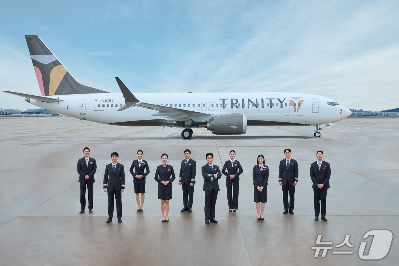 지난 1일 티웨이항공 운항, 객실승무원들이 김포국제공항에서 트리니티항공 신규 리버리 적용 항공기 도입을 기념해 촬영을 하고 있다.(티웨이항공 제공)