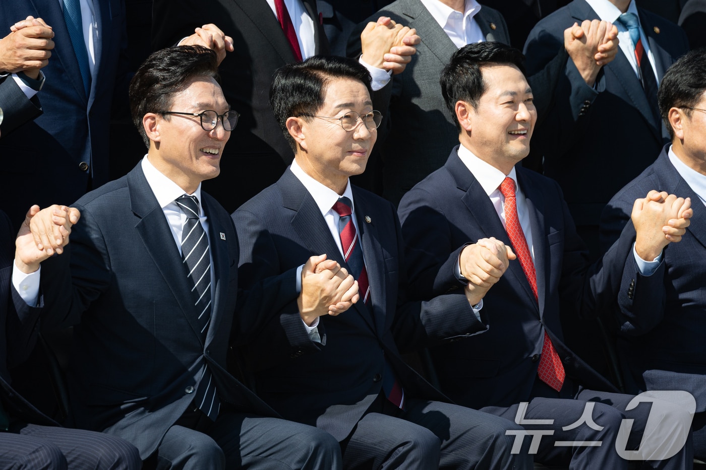 조정식 국회의장과 더불어민주당 김민석, 국민의힘 장동혁 대표가 3일 서울 여의도 국회에서 제22대 국회 후반기 국회의원 단체사진 촬영 중 손을 맞잡고 있다. 2026.9.3 ⓒ 뉴스1 유승관 기자