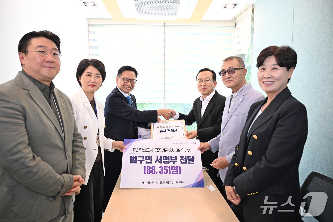 이동권 북구청장(왼쪽에서 세번째)이 7일 청와대를 방문해 김태근 자치발전비서관(오른쪽 세번째)에게 공공기관 2차 이전 유치 건의서와 범구민 서명부를 전달했다.2026.09.07.(울산 북구 제공. 재판매 및 DB금지)/뉴스1