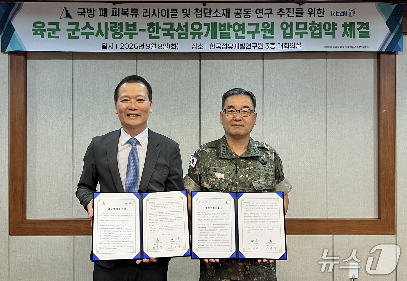 김성만 한국섬유개발연구원장(왼쪽)과 박춘식 육군 군수사령관이 '국방 폐 피복류 리사이클 및 첨단소재 공동 연구 추진'을 위한 업무협약을 체결한 뒤 협약서를 펼쳐 보이고 있다.